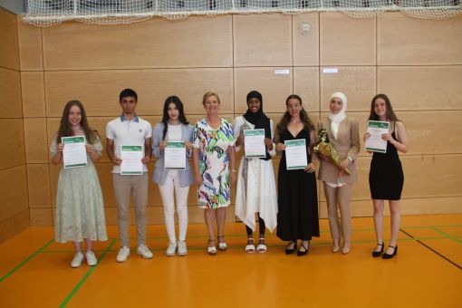 Direktorin Behling (4. von links) auf dem gemeinsamen Foto mit den Klassenbesten (v.l.n.r.): Julie Gleitsmann, Atakan Cakmak, Diana Wahidi, Sabiren Abdillahi Hussein, Aurelia Chanel Risplendente, Ghazal Abdullah und Milla Berwanger.